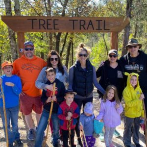 Blog - Family and Friends Smiling Outside Under a Sign Saying Tree Tail